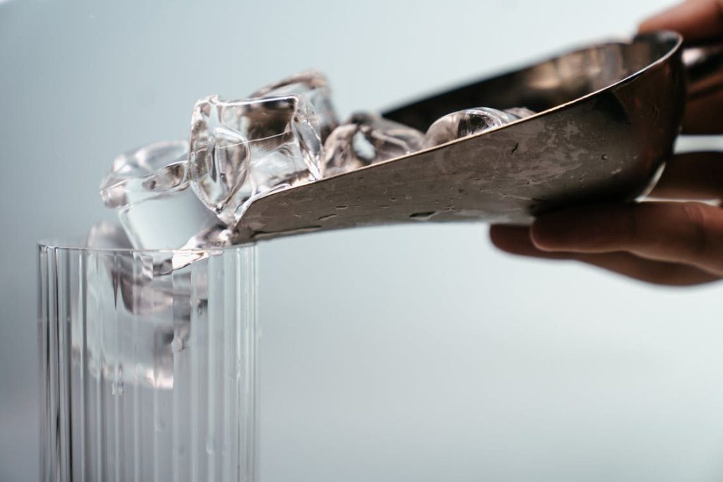 Ice Cubes Being Poured into a Glass from an Ice Scoop