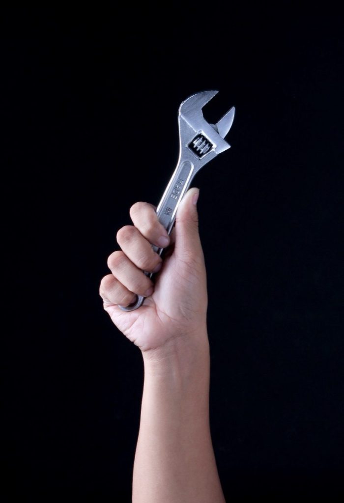 A person holding a wrench in their hand
