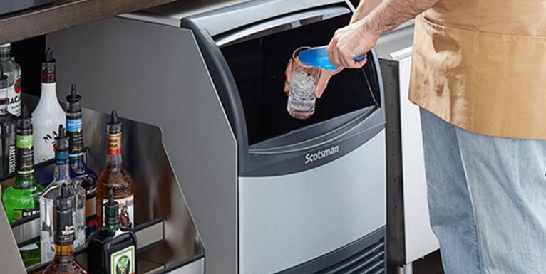 An image of a person putting ice in the glass from an ice machine