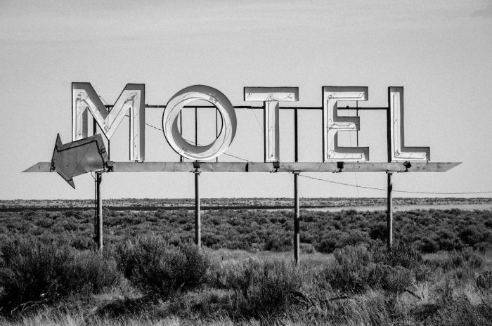 Grayscale photo of a motel sign.
