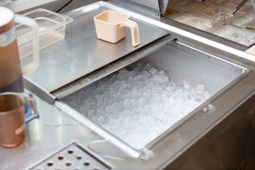 An image of a commercial ice machine storage bin filled with ice cubes