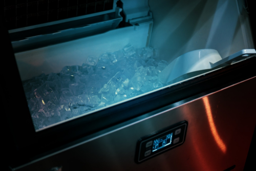 silver colored ice machine with blue light