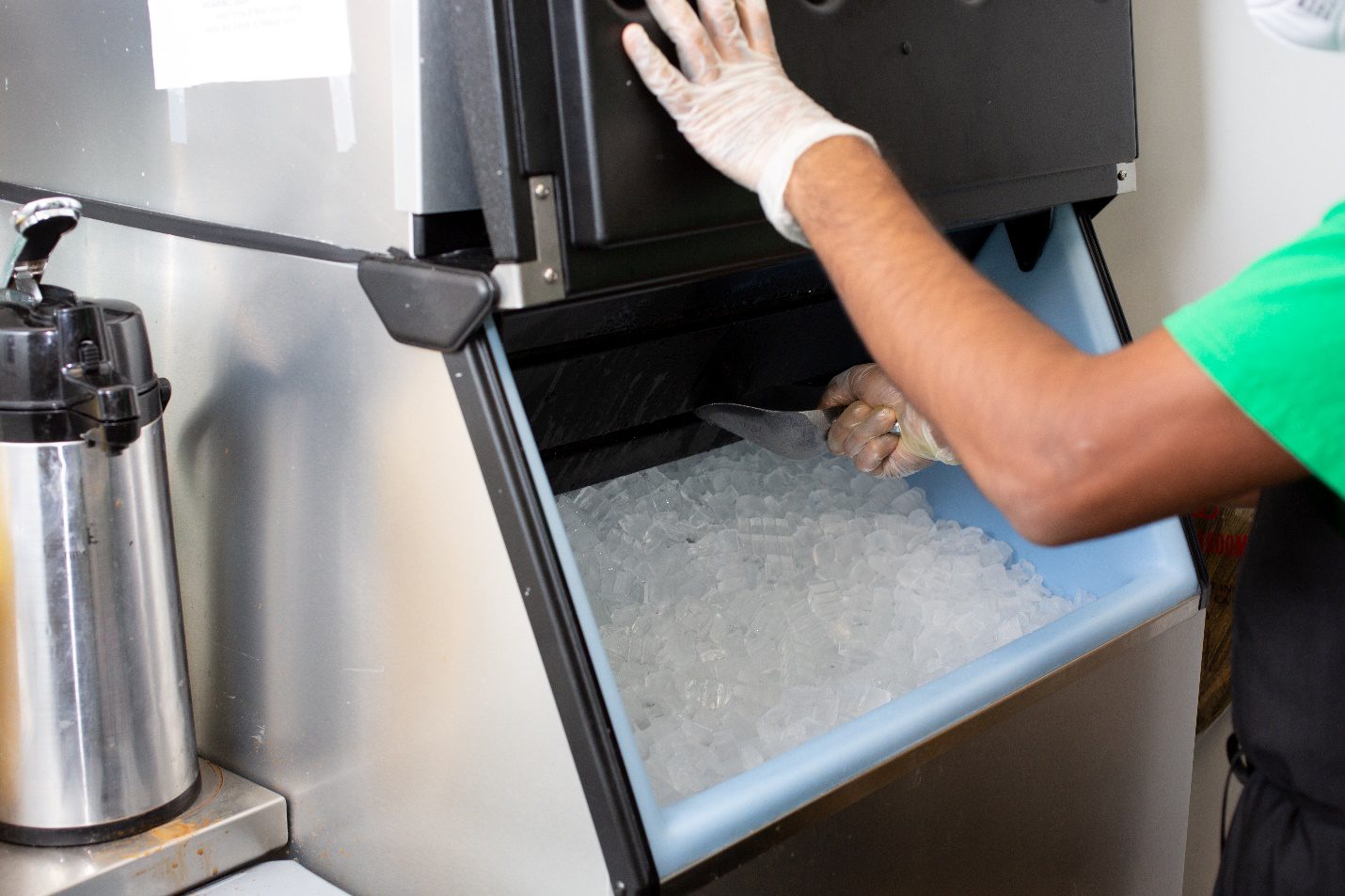an employee scooping ice from an ice machine