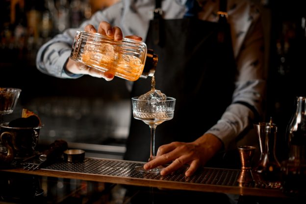 a bartender pouring a cocktail