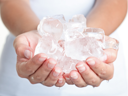 An image of a person holding ice cubes from an ice machine in their hands
