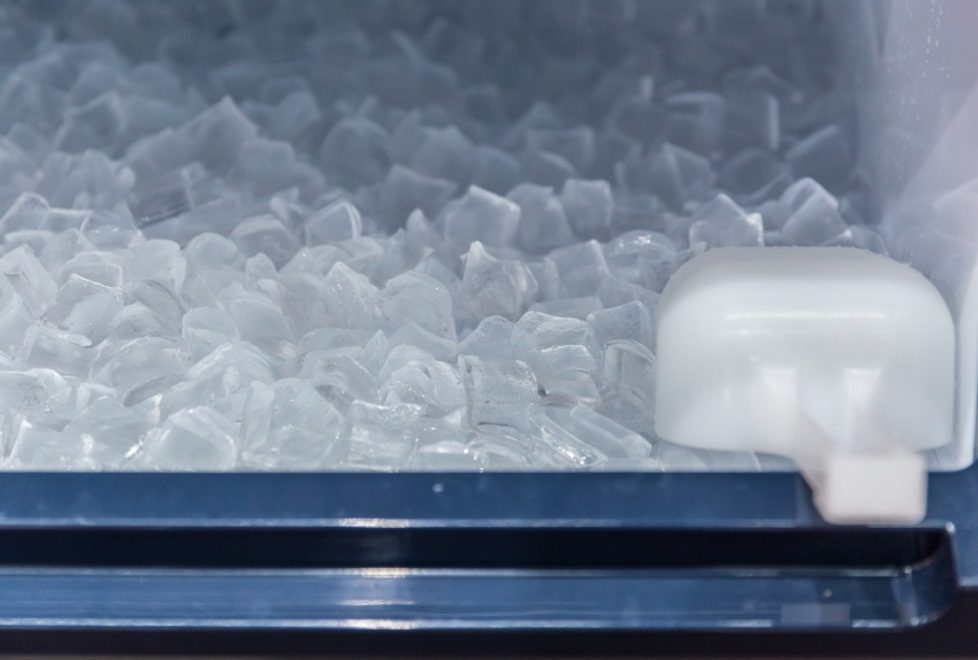 Ice in an ice machine and a white scooper